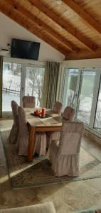 a dining room with a wooden table and chairs at Holiday home Vila Bjelašnica in Bjelašnica