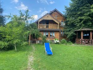 Tukhlya的住宿－Oselia Mandrivnykiv，木屋前的蓝色草坪椅
