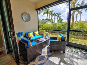 a screened in porch with wicker chairs and a table at Luxury Oasis - Pool, BBQ, Patio - Cape Coral, Florida in Cape Coral