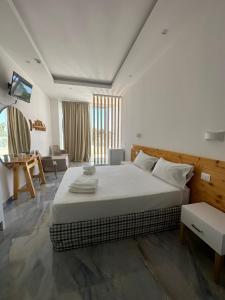 een slaapkamer met een groot bed en een woonkamer bij Jonium Hotel Residence in Pulsano