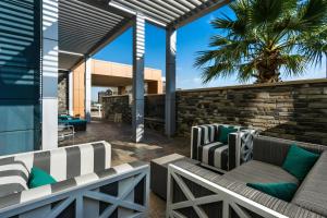a patio with two couches and a palm tree at SpringHill Suites by Marriott Midland Odessa in Midland