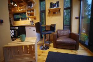 uma sala de estar com uma cadeira e um banco em Ski House Szczyrk - Domek Na Kurzej Łapce em Szczyrk