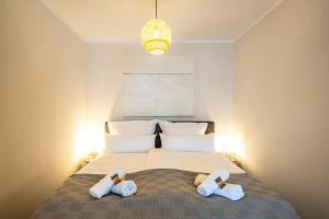 ein Schlafzimmer mit einem Bett mit zwei Handtüchern darauf in der Unterkunft FeWo Ahrperle-modernes Apartment-Balkon-Kurviertel in Bad Neuenahr-Ahrweiler