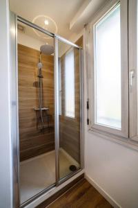 - une douche en verre dans une chambre avec fenêtre dans l'établissement Appartement climatisé gare St-Charles, à Marseille