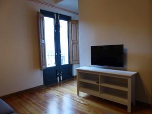 un salon avec une télévision à écran plat sur une armoire dans l'établissement Apartamento Ábside de San Juan III, à Estella