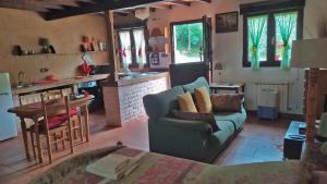 La Casa de la Vieja في Nava: غرفة معيشة مع أريكة ومطبخ