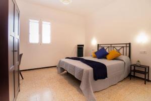 Schlafzimmer mit einem Bett mit blauen und gelben Kissen in der Unterkunft Casa Sunshine Paradise in Vecindario