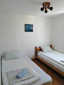 1 dormitorio con 2 camas y ventilador de techo en Danica apartmani en Nin