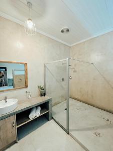 y baño con ducha y lavamanos. en Lighthouse Guesthouse & Cafe, en Groblersdal