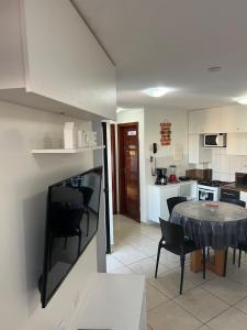 a kitchen and dining room with a table and chairs at Beautiful flat Ponta Negra sem custos adicionais! in Natal