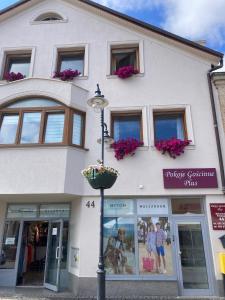 a white building with windows and a street light at Pokoje Gościnne PLUS in Ustka