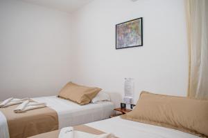 Un dormitorio con dos camas y un cuadro en la pared. en Hubun Hotel Boutique, en Los Ayala 25 fotos más