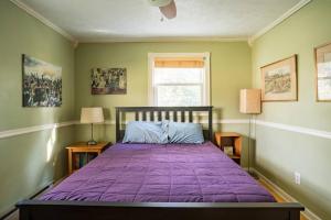 een slaapkamer met een paars bed met 2 lampen en een raam bij Pet-Friendly Escape 5 Miles from Blowing Rock in Blowing Rock