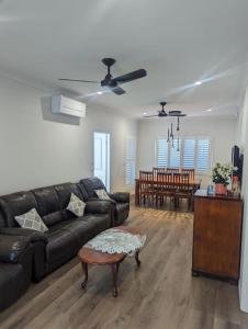 a living room with a black leather couch and a table at Entire House near Brisbane City 2Beds in Brisbane