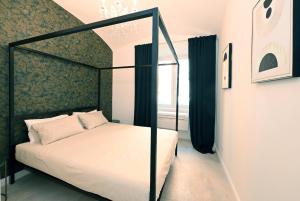 een slaapkamer met een hemelbed en een raam bij VATICAN DESIGN APARTMENTS in Rome