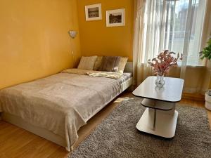 een slaapkamer met een bed, een tafel en een raam bij Center of city apartments, bus station 1min, airport 5 min in Tallinn