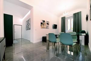 een eetkamer met een tafel en groene stoelen bij VATICAN DESIGN APARTMENTS in Rome