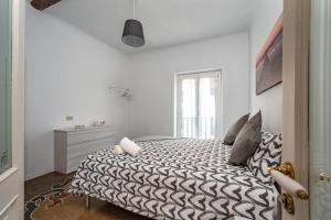 a bedroom with a black and white bed with a window at Seaside Apartment Genova in Genoa