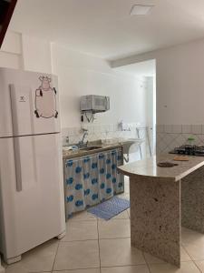 a kitchen with a white refrigerator and a counter at Verde e Mar in Angra dos Reis