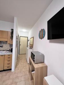 a kitchen with a microwave and a television on a wall at baiasole in Sanremo