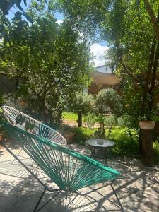 a green bench and a table in a garden at Casa Matia Bed and Breakfast in San Miguel de Allende