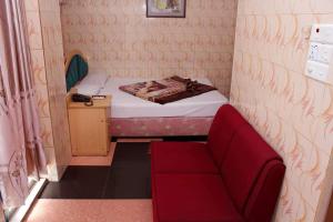 Habitación pequeña con silla roja y cama en Saint Martin Resort, en Cox's Bazar