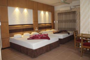 two beds in a room with a table and chairs at Saint Martin Resort in Cox's Bazar