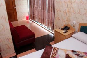 a room with a red chair and a phone at Saint Martin Resort in Cox's Bazar +16 photos