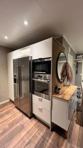 a kitchen with a stainless steel refrigerator and a mirror at Holiday Home Ljungskile in Ljungskile