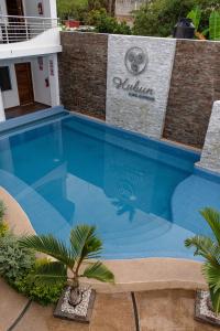 Una gran piscina azul frente a un edificio en Hubun Hotel Boutique, en Los Ayala
