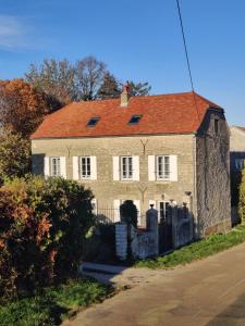 una antigua casa de ladrillo con techo rojo en La Flavignienne en Flavigny-sur-Ozerain