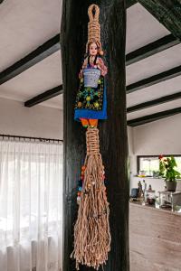 a wooden wall with a doll hanging on it at Pensiunea Casa de Vis in Bughea de Sus