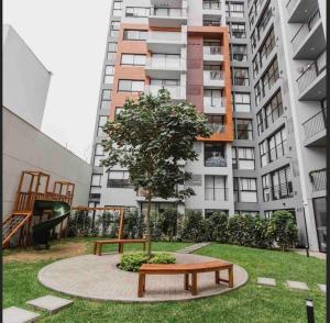 un parque con un banco y un árbol frente a un edificio en Stylist and modern 1BR in Lima, en Lima