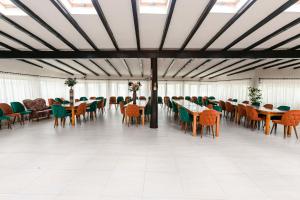 Pensiunea Casa de Vis في Bughea de Sus: صالة طعام بها طاولات وكراسي ونوافذ