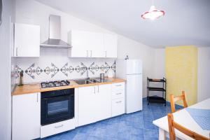 a kitchen with white cabinets and a stove top oven at La Casa del Maestro Attico in Pisciotta