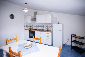 a kitchen with a table and a white refrigerator at La Casa del Maestro Attico in Pisciotta