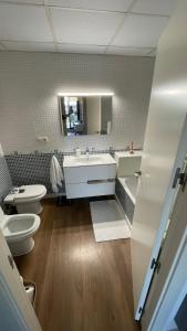 ein Badezimmer mit einem Waschbecken, einem WC und einem Spiegel in der Unterkunft Atico Canet de Berenguer in Canet d'en Berenguer