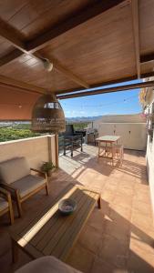 eine Terrasse mit einem Tisch, einer Bank und einem Tisch in der Unterkunft Atico Canet de Berenguer in Canet d'en Berenguer
