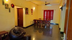 uma sala de estar com uma mesa de jantar e cadeiras em PALAZHI em Kovalam