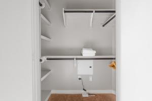 a closet with white walls and a shelf at Luxury Oasis I Mins from TX Med Center-FREEParking in Houston