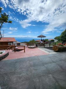 a patio with picnic tables and a view of the ocean at Rosegarden View in Velas