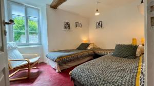 - une chambre avec deux lits, une chaise et une fenêtre dans l'établissement L'Escapade de Pierrefonds par Your Sweet Loc, à Pierrefonds
