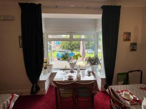 a dining room with a table and a window at Berry Hotel in Paignton