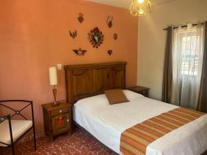 a bedroom with a bed and a chair with butterflies on the wall at Casa Matia Bed and Breakfast in San Miguel de Allende