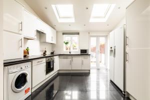 a kitchen with white cabinets and a large skylight at The Broadway Bath - 2 Bedrooms with parking, Central Bath in Bath
