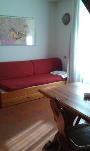 sala de estar con sofá rojo y mesa en Residence Cervinia Due - Maisonnette nr A7A04, en Breuil-Cervinia