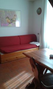 a living room with a red couch and a table at Residence Cervinia Due - Maisonnette nr A7A04 in Breuil-Cervinia