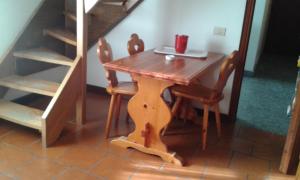 Una mesa de madera con dos sillas y una computadora portátil encima. en Residence Cervinia Due - Maisonnette nr A7A04, en Breuil-Cervinia