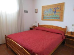 1 dormitorio con cama de madera y colcha roja en Residence Cervinia Due - Maisonnette nr A7A04, en Breuil-Cervinia