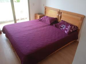 a bedroom with a purple bed with purple sheets and pillows at TAMARIs in Tamaris +5 photos